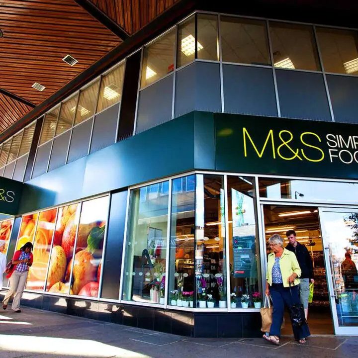 Exterior of an m&s simply food store with pedestrians walking by.